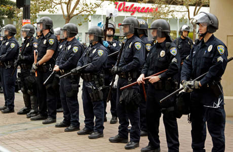 Oakland police officers in riot gear line Frank H. Ogawa plaza, the site of an Occupy Wall Street encampment,