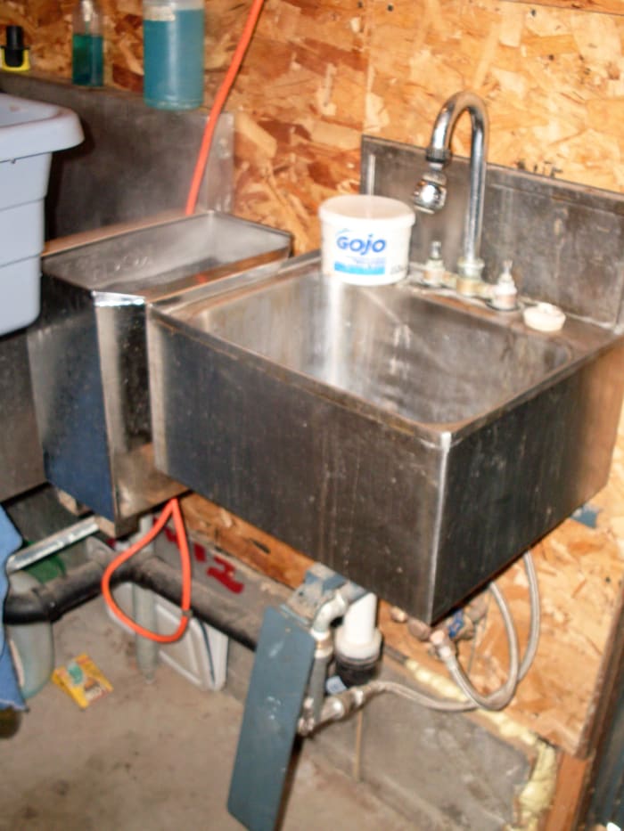 Indoors in the meat room (my father processes a lot of meat), a no-touch hand-washing station is excellent. The water is controlled by a knee-press pedal. That's an automatically-heated knife scalder next to the sink.