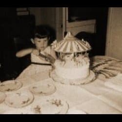 That's me, at the age of four or five. My mom took the picture, or my dad... not sure which one, really. Mom used to buy lovely birthday cakes from the bakery. This one was a carousel with animal figurines on it.