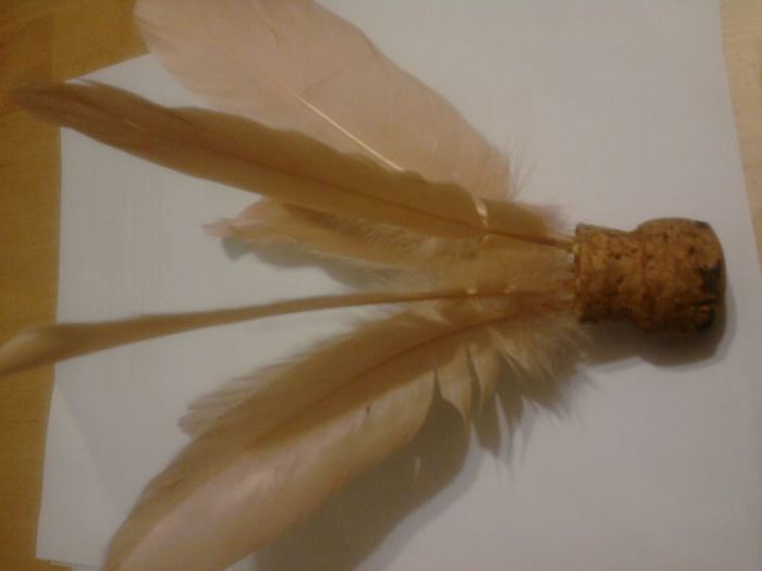 This is a basic representation of a shuttlecock, made with a campaign cork and some craft feathers.