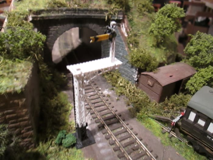 The tunnel mouth exit at Ayton Lane mpd with the bracketed distant 'on' (Ratio kit). Van body with weathered and 'rust perforated' corrugated (aluminium) roof; scatter, lichen and trees. Track to be ash/cinder ballasted