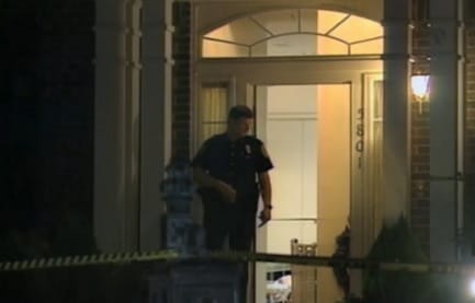Rowlett police officer Steve Wade stands guard at the front door of the Routier home as the crime scene is being processed in the early morning hours of the murders