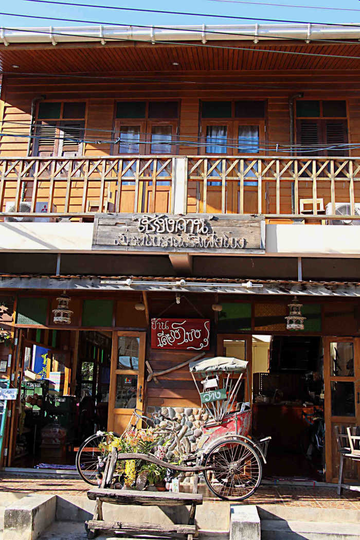 An original teakwood building, with a rickshaw in front - a sign of Chiang Khan catering to the tourist invasion