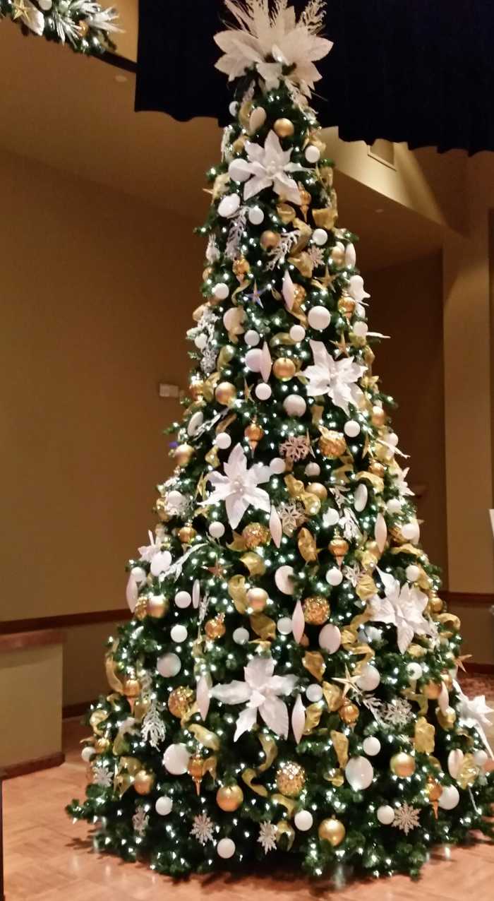 A tree at Solivita that's loaded with bling with lots of gold and shiny white covering every inch of the oversize tree.