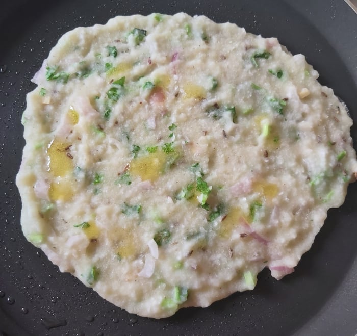 Sprinkle some drops of ghee on rotti. Cover and cook for a minute in a medium flame till above side cooked properly.