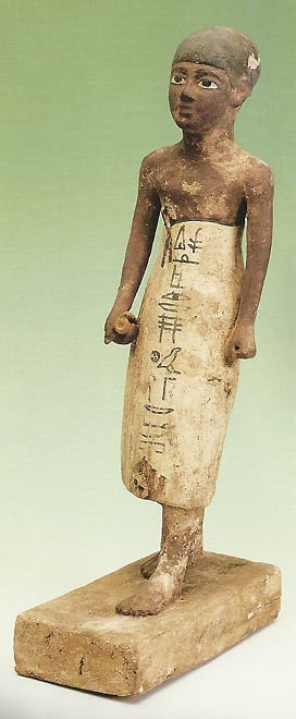 A Priest with a papyrus scroll in his right hand; on his skirt the first words of a prayer to Osiris(Middle Kingdom)