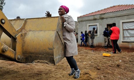 A South African woman unsuccessfully tries to prevent the demolition her home in Lenasia last week