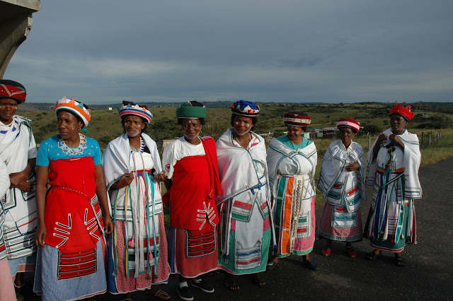 Xhosa ladies.It is important for women to look dignified at all times particularly if there is a cultural ritual. Women must cover their head at all times and have a scarf around their waist and have something to put on their shoulders. This is a si