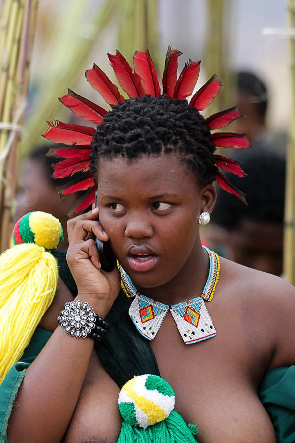 Swazi Girl in her traditional adornment and with a cell phone to go with that too. African Culture meets modernity