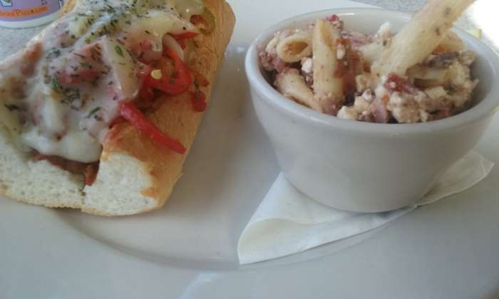 Served at Brixx Pizza Restaurant (dine-in) - hot and delicious saucy meatball sandwich with melted cheese and roasted red bell peppers on top plus a flavorful side pasta salad and pickle