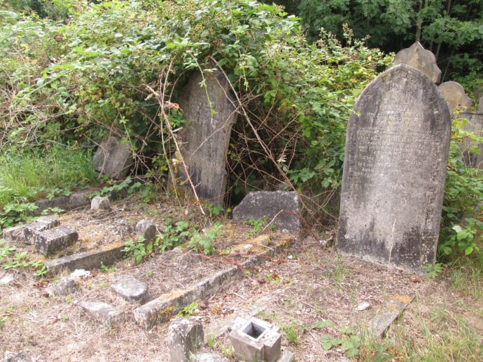 Faint traces of the surrounding grave-top stonework can be made out, ferns and ivy are encroaching. The trees will be next unless the cemetery groundsmen work faster to keep it at bay...