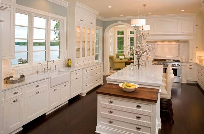 glass cabinet door add character to a classic white kitchen - accented with wood flooring and arched door ways