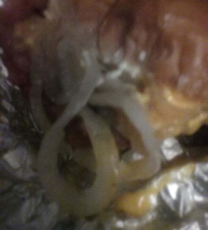 burger with various toppings including cheese and lots of grilled onion slices from Cook Out Fast Food Restaurant