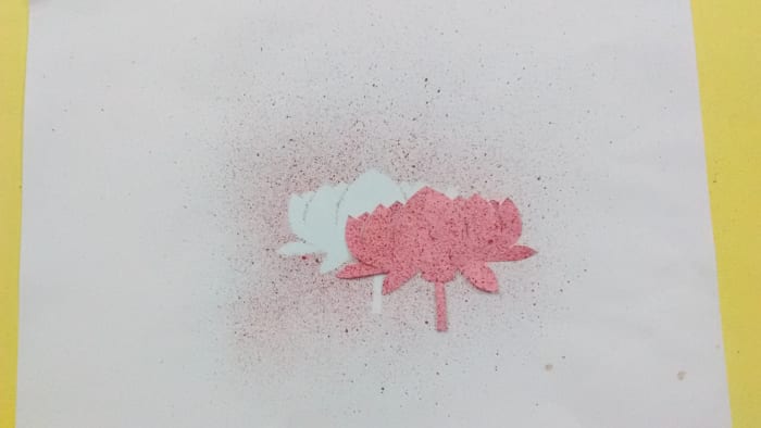 Next place the flower cutout over the previous spray painting. But this time displace the flower little outwards.
