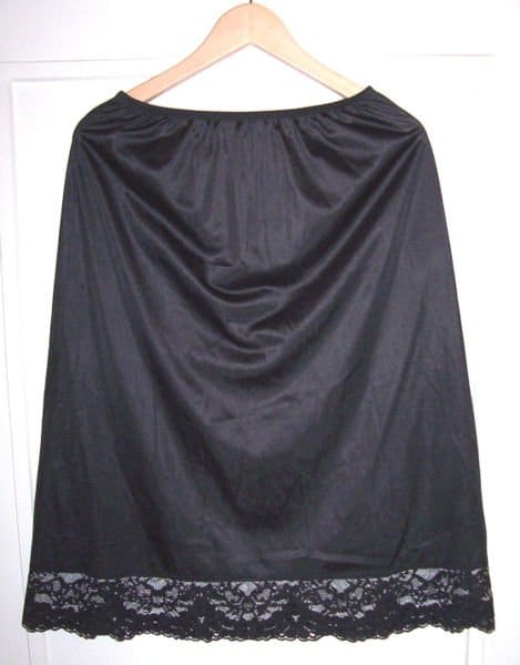 A black Vassarette vintage half slip with lace trim at the hem from the photos of Geneviève on Wikipedia