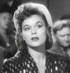 The square face of Jean Hagen is feminized by asymmetrical curls and a dashing wave on her forehead.