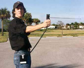 Andrew Harter (Skeptics Society) "aiming" a Quadro Tracker, note the free swirvel antenna on the hand-held portion, and a belt/pocket module connected by a wire. (We'll get back to that)