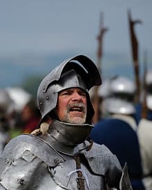 Armor on an re-enactor dressed as a medieval knight, note the full curved plates cover all spots, including throat and armpits.