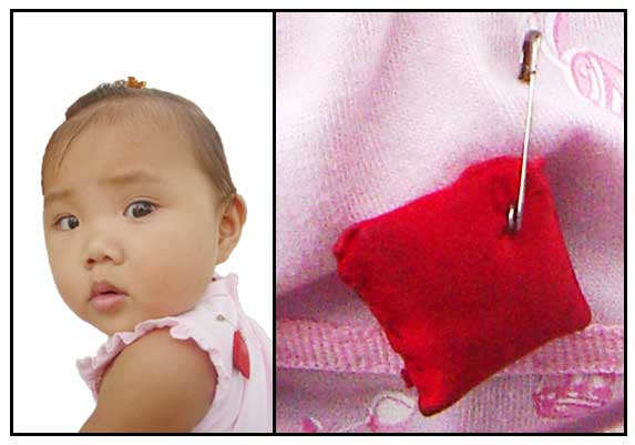 A charm pinned on clothes of babies is believed to ward off the greeting-induced malady called bati.