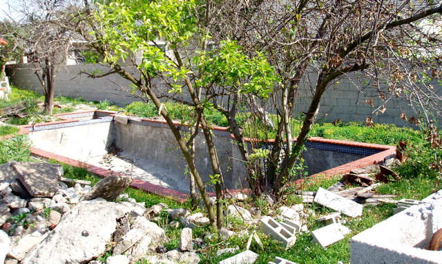 Small backyard pool under construction. After the pool is built, the owner will work with the landscape around it.