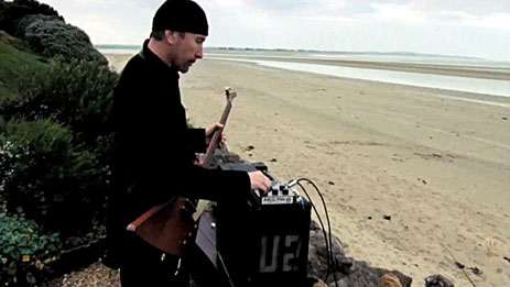 The Edge adjusts a vintage EHX Deluxe Memory Man pedal in a scene from the film "It Might Get Loud."