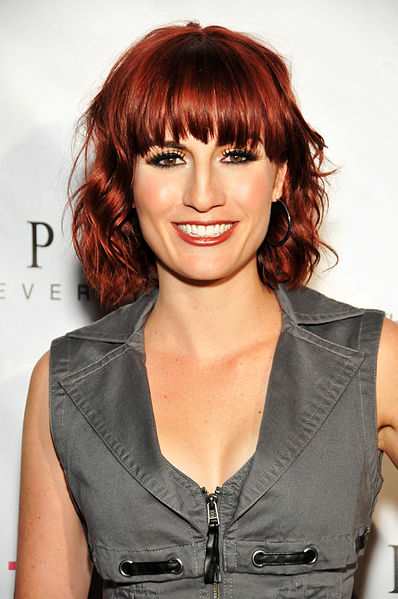 Dark red hair color for warm skin, in a short wavy hairstyle with bangs