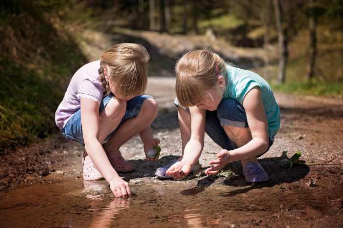 Constructing a fairy garden entices children outdoors. Here, the girls are finding smooth pebbles to make a path in their miniature garden.