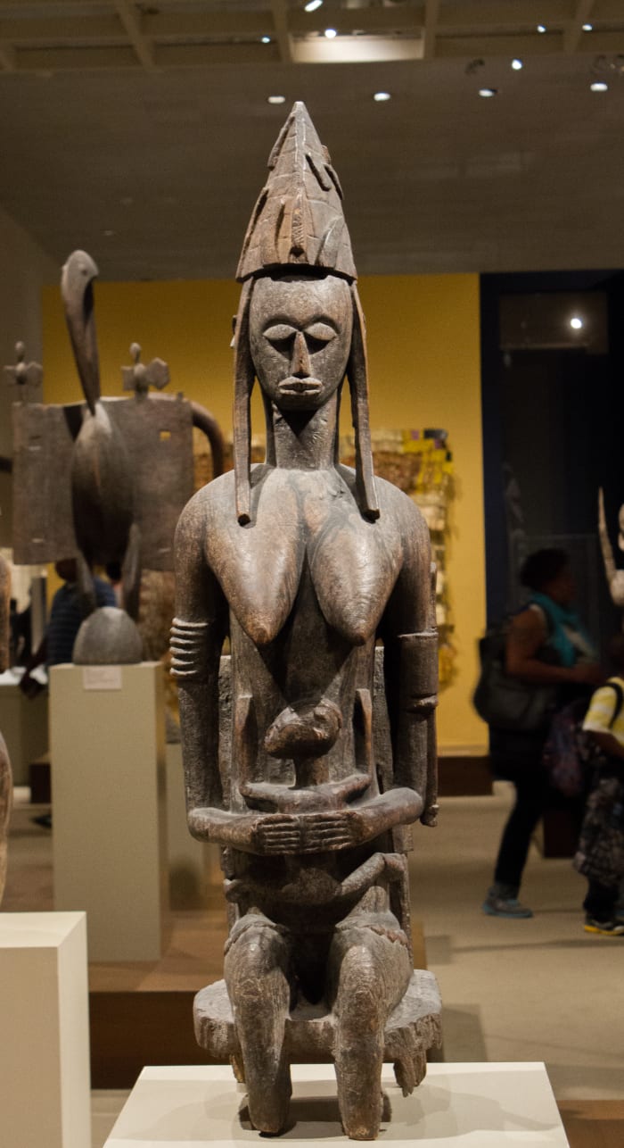 This African statue is of the primordial male, the first man. It shows him sitting tall and proud.