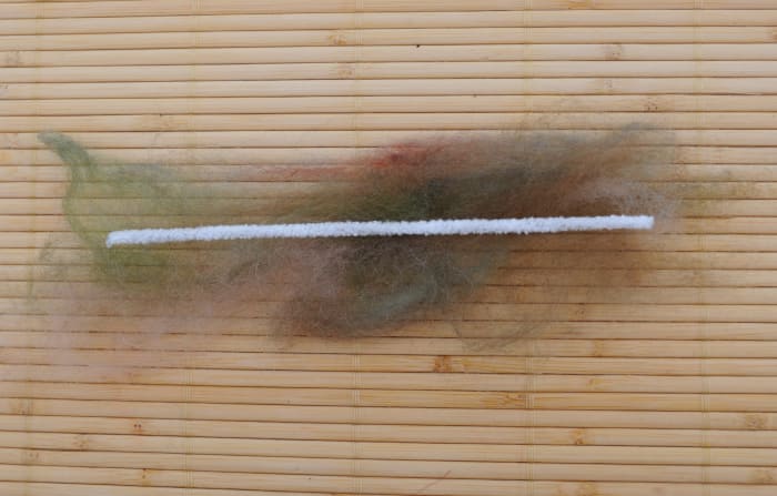 Place a cotton pipe cleaner on top of the thin layer of green fibers to make the stem