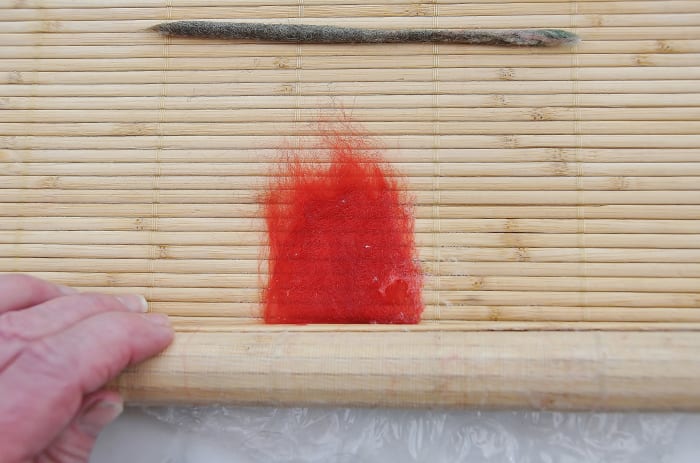 Roll inside the mat but avoid the top section of the wool. These fibers must not be rolled yet.