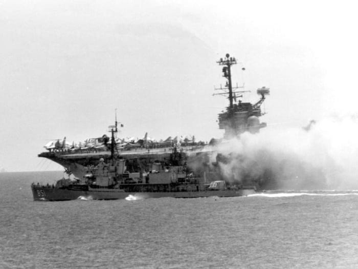 USS Forrestal on fire, the worst US carrier fire since WWII; USS Rupertus (DD-851) maneuvers to within 20 ft (6.1 m) to use fire hoses.