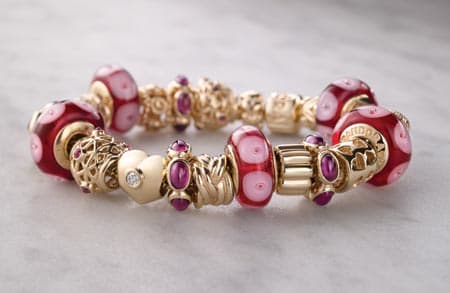 beautiful story book pink and fuscia and gold Pandora bracelet complete with intricate charms of hearts and murano glass