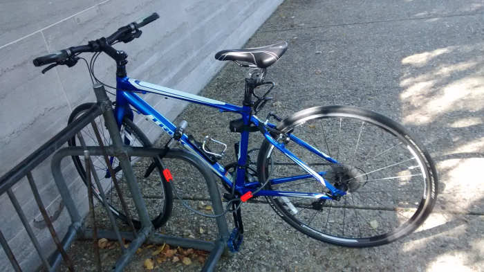 U-Lock secures front wheel and bike frame to a solid rack; a cord lock with loops attaches to the U-lock and secures the rear wheel; the seat is also secured; no easily removable parts are left while parked.