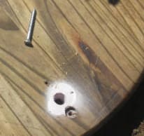Toward the center is the hole used for your finger to align with the stake. The stake will be located below the counter sunk hole. A screw is driven easily into the stake with your power drill.