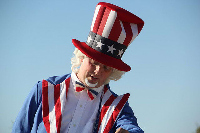 4th of July American symbol is a man dressed in red,white, and blue- colored suit which is topped off with a tall hat showing the stars and stripes representing the American flag. He is known as "Uncle Sam".