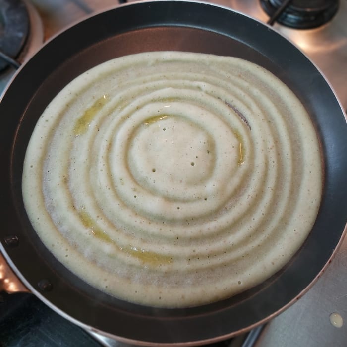 Smear a few drops of ghee on the dosa. Cover and cook on medium to low heat for about 1 minute or till it has cooked properly.