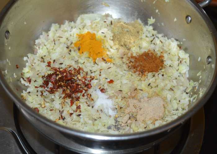 Step two: Reduce the heat and add all the spices, such as turmeric powder, chili flakes, coriander powder, dry mango powder, garam masala powder, and remaining salt.
