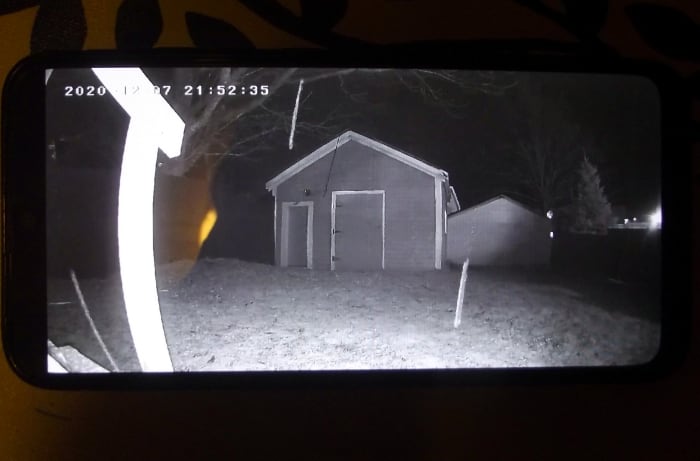 View of garage taken from back steps using camera's infrared lights. The thick streaks are drops of falling rain