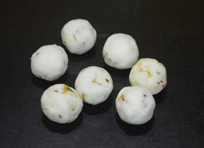 Join the open end to cover the stuffing on all sides. By rolling it between your palms, get a proper ball shape. Similarly, make other dough balls. Next, you have to roast or shallow-fry these balls.
