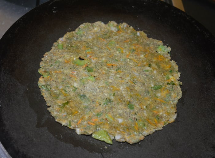 When the bottom becomes golden brown, flip it. Add a few drops of oil on the surface. Allow the bottom side to get golden brown spots. Cooking a roti takes about 3 minutes.