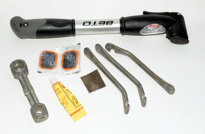 Puncture Repair Tools. A pump, multiwrench for different sized nuts, tire levers, patches, glue and emery paper..