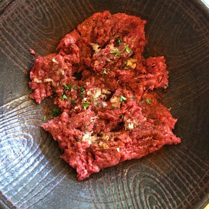 The beef should be bright red. You should see a little fat marbling throughout. If it is brown or grey, it's too old.