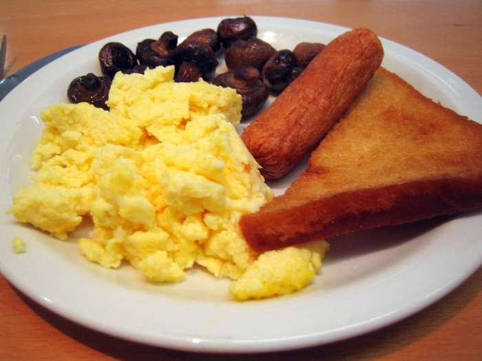Scrambled eggs with veggie sausages, mushrooms, and fried bread makes a delicious breakfast or lunch.