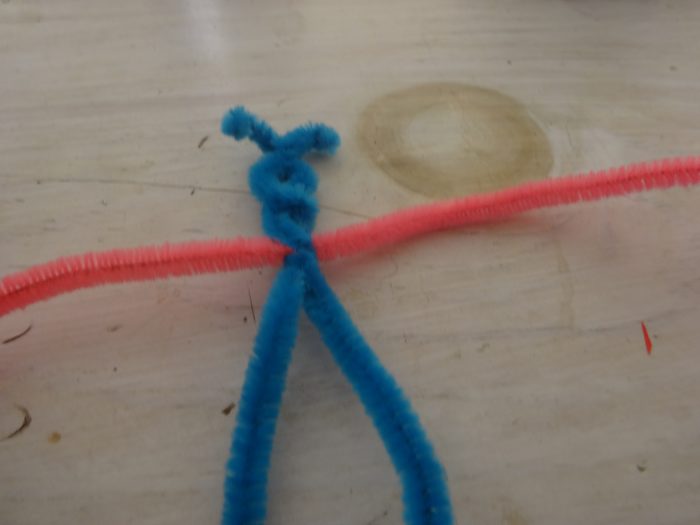 Thread another pipe cleaner through the first and so the middle goes through it and twist them together