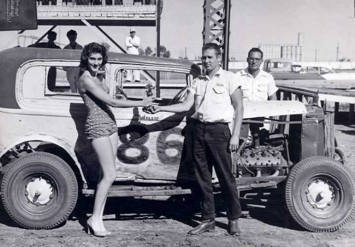 Wilbur “Willie” Berger of Newton, Kansas is shown here receiving the trophy that he was presented for winning the trophy dash at the Kansas State Fairgrounds, Labor Day 1957.