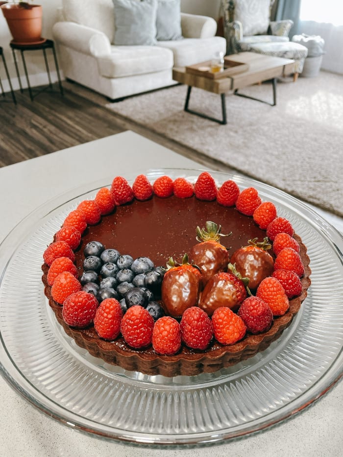 Voila! A beautifully decorated chocolate tart with fresh raspberries, blueberries, and strawberries. The dark chocolate filling is smooth, rich, and delicious.