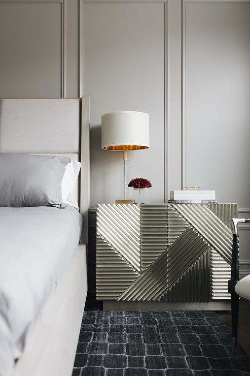 The bed wingback upholstered is the silver nightstand with the gold lamp. The rug is the gray wainscoted wall and the bedding gray sheets and comforter.