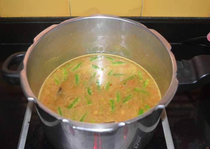 Step four: Add 6 cups of water and bring the mixture to boil. At this stage, check for taste. Add more salt or red chili powder if you want. Cover the pressure cooker with the lid. Place the weight.