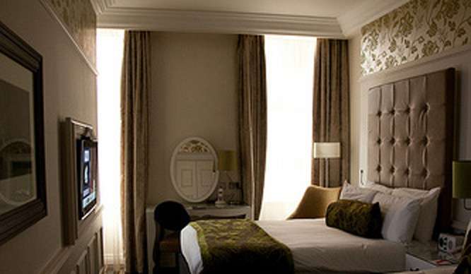 An oversize headboard and soothing paint color are just the touches to transform your bedroom into a chic boutique hotel room.