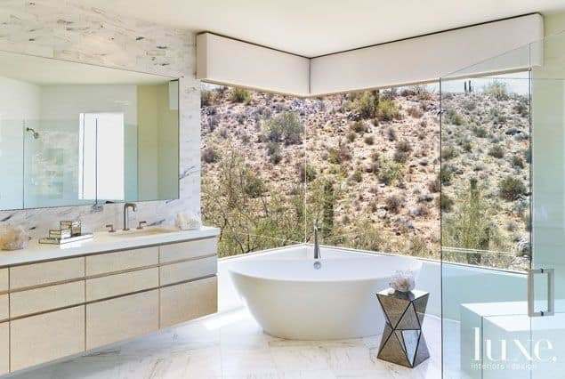 Tumbleweeds rule in the backyard Scottsdale home. The luxury bath has windows overlooking desert hills.